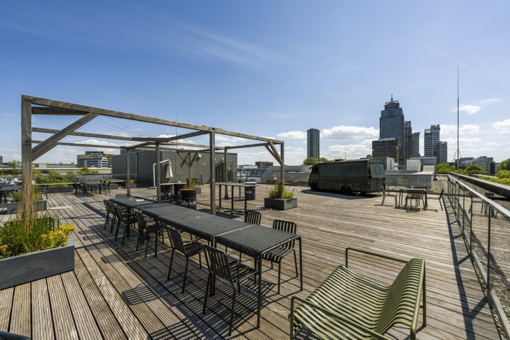 Spacious rooftop terrace on Mr. Treublaan with outdoor seating, wooden pergola, and city skyline views.